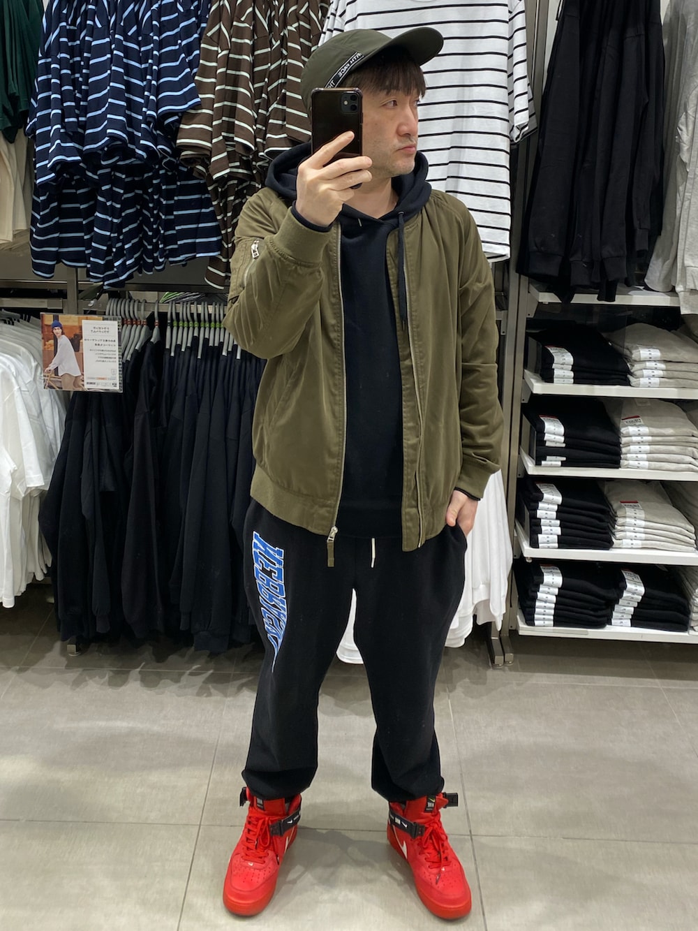 ブラック系のパーカー、グリーン系のMA-1、ブラック系のスウェットパンツを着用したメンズの春コーディネートの2枚目の写真