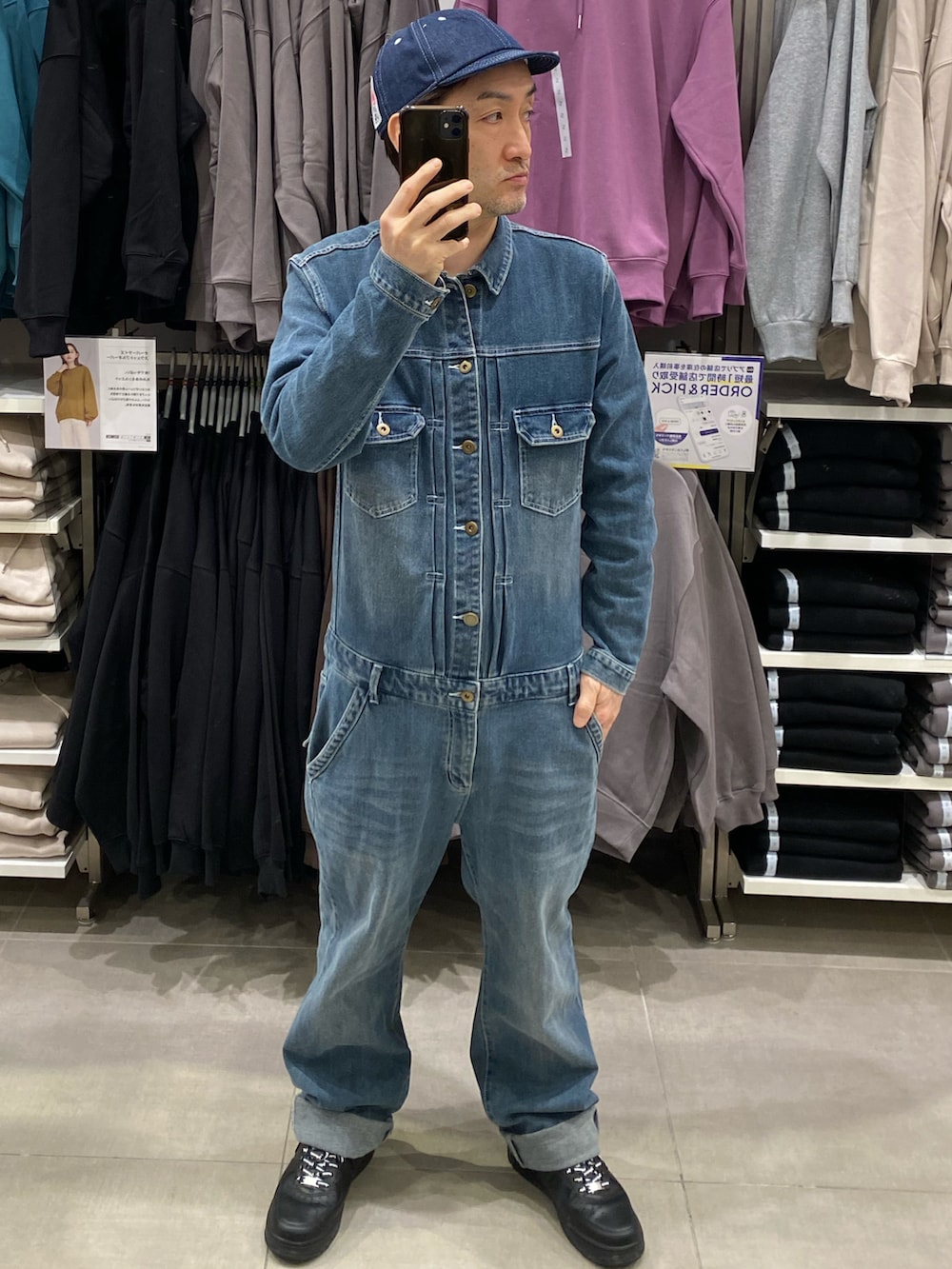 ブルー系のつなぎ/オールインワン、ブラック系のスニーカー、ブラック系のダウンベストを着用したメンズの秋コーディネートの3枚目の写真