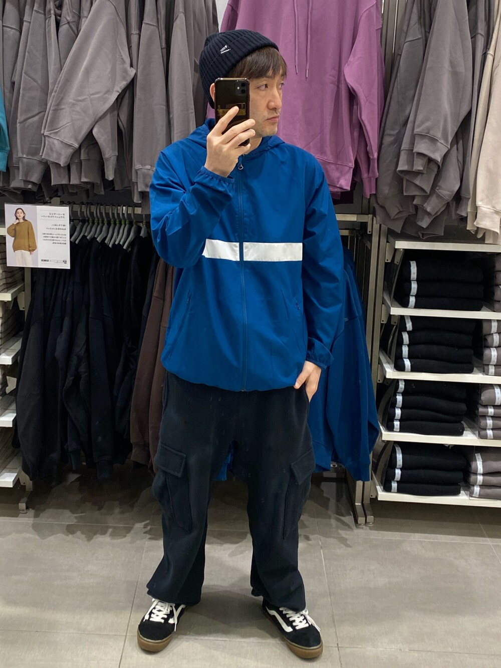 ブルー系のナイロンジャケット、ブラック系のカーゴパンツ、ブラック系のスニーカーを着用したメンズの秋コーディネートの4枚目の写真