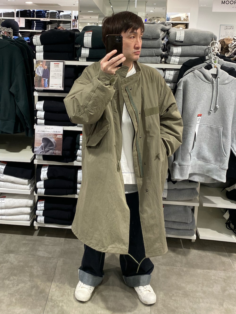 ホワイト系のスウェット、グリーン系のモッズコート、ブルー系のカーゴパンツを着用したメンズの冬コーディネートの3枚目の写真