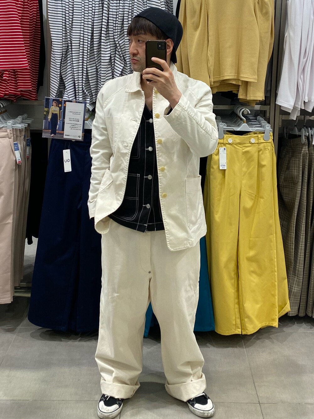 ブラック系のその他アウター、ホワイト系のカバーオール、ブラック系のスニーカーを着用したメンズの春コーディネートの4枚目の写真