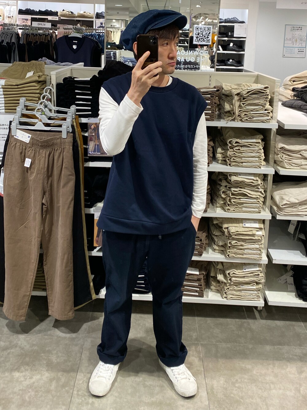 ブルー系のその他パンツ、ホワイト系のスニーカー、ブルー系のベストを着用したメンズの秋コーディネートの2枚目の写真