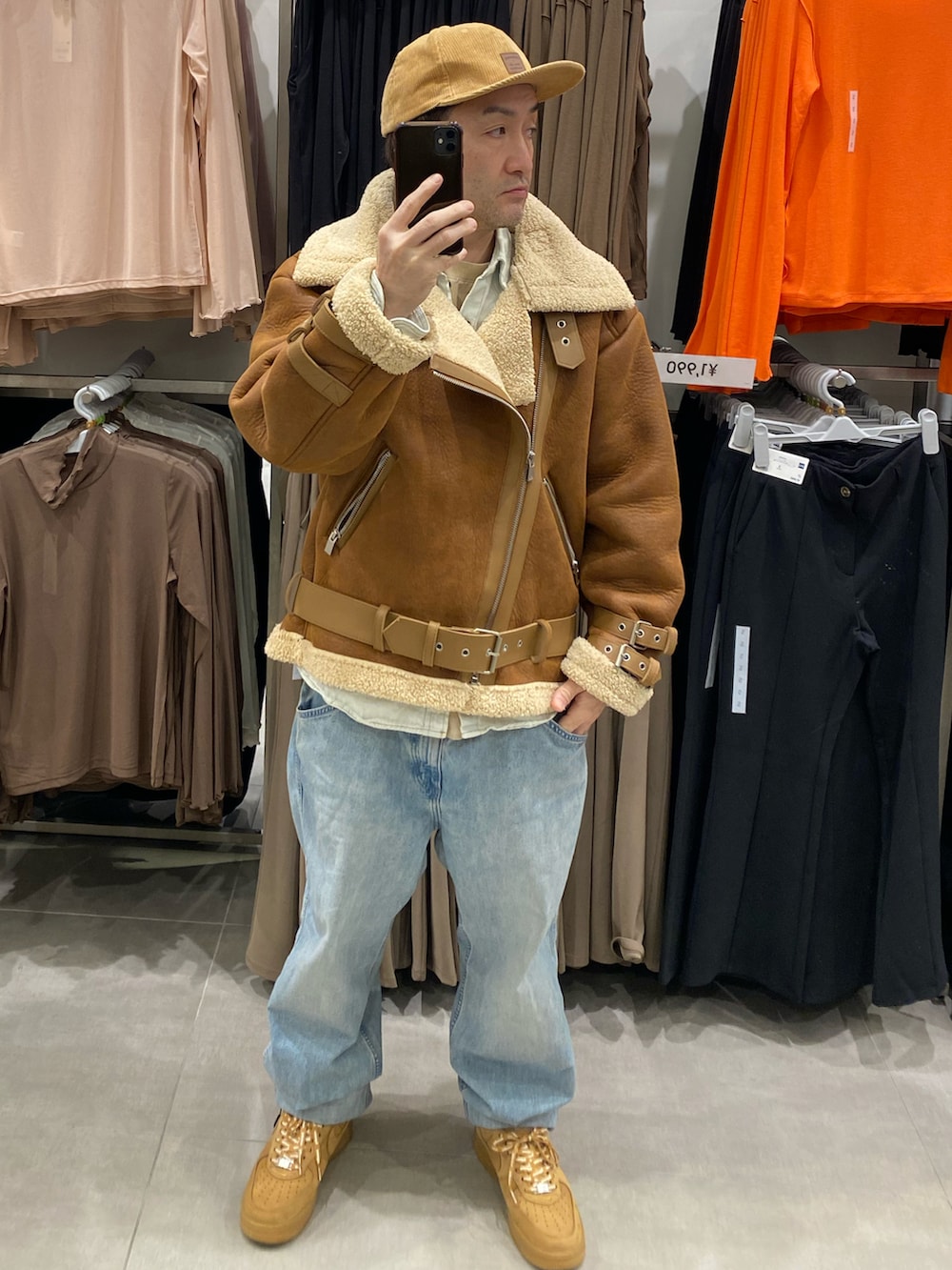 ブルー系のシャツ/ブラウス、ブラウン系のムートンコート、ブルー系のデニムパンツを着用したメンズの冬コーディネートの4枚目の写真