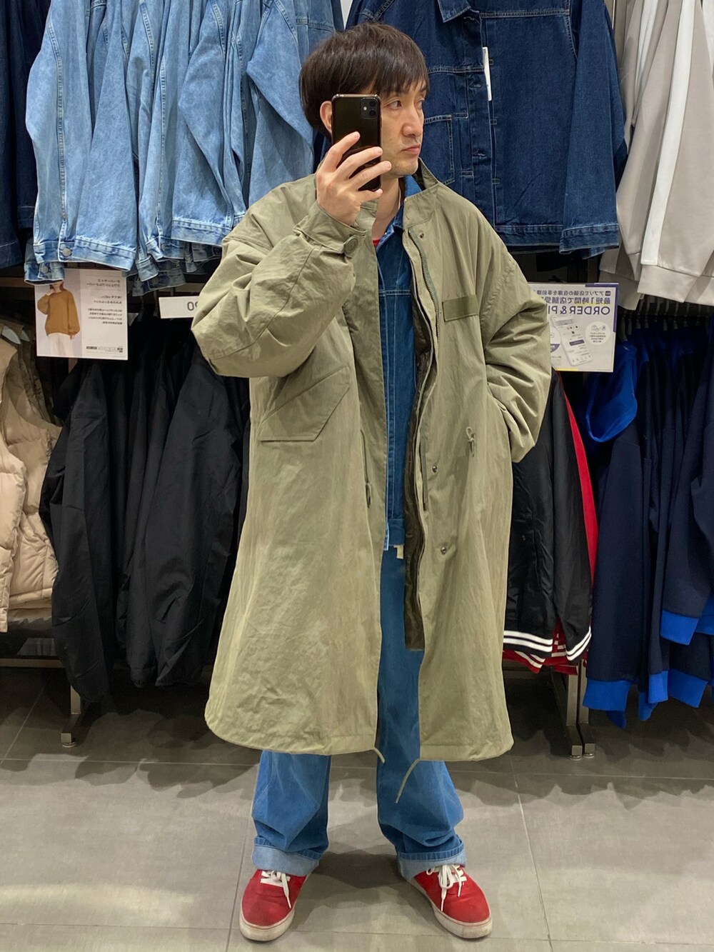 グリーン系のモッズコート、ブルー系のデニムジャケット、ブルー系のデニムパンツを着用したメンズの秋コーディネートの3枚目の写真