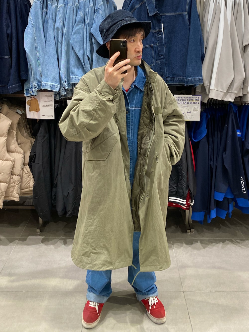 グリーン系のモッズコート、ブルー系のデニムジャケット、ブルー系のデニムパンツを着用したメンズの秋コーディネートの2枚目の写真