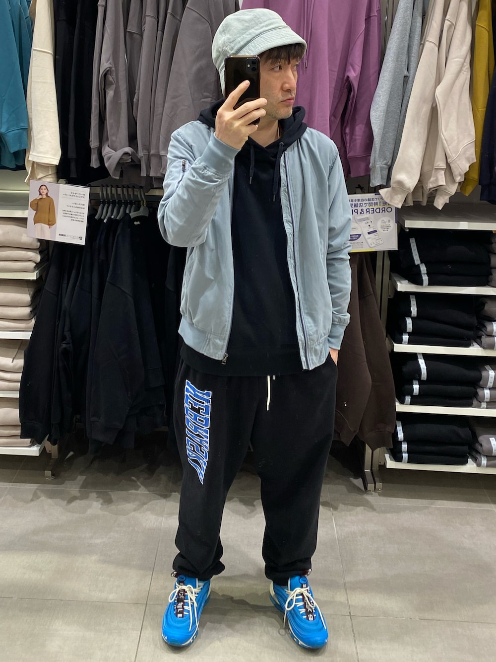 ブラック系のパーカー、ブルー系のMA-1、ブラック系のスウェットパンツを着用したメンズの秋コーディネートの2枚目の写真