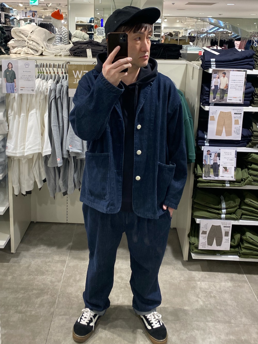 ブラック系のテーラードジャケット、ブラック系のスニーカー、ブラック系のキャップを着用したメンズの春コーディネートの2枚目の写真