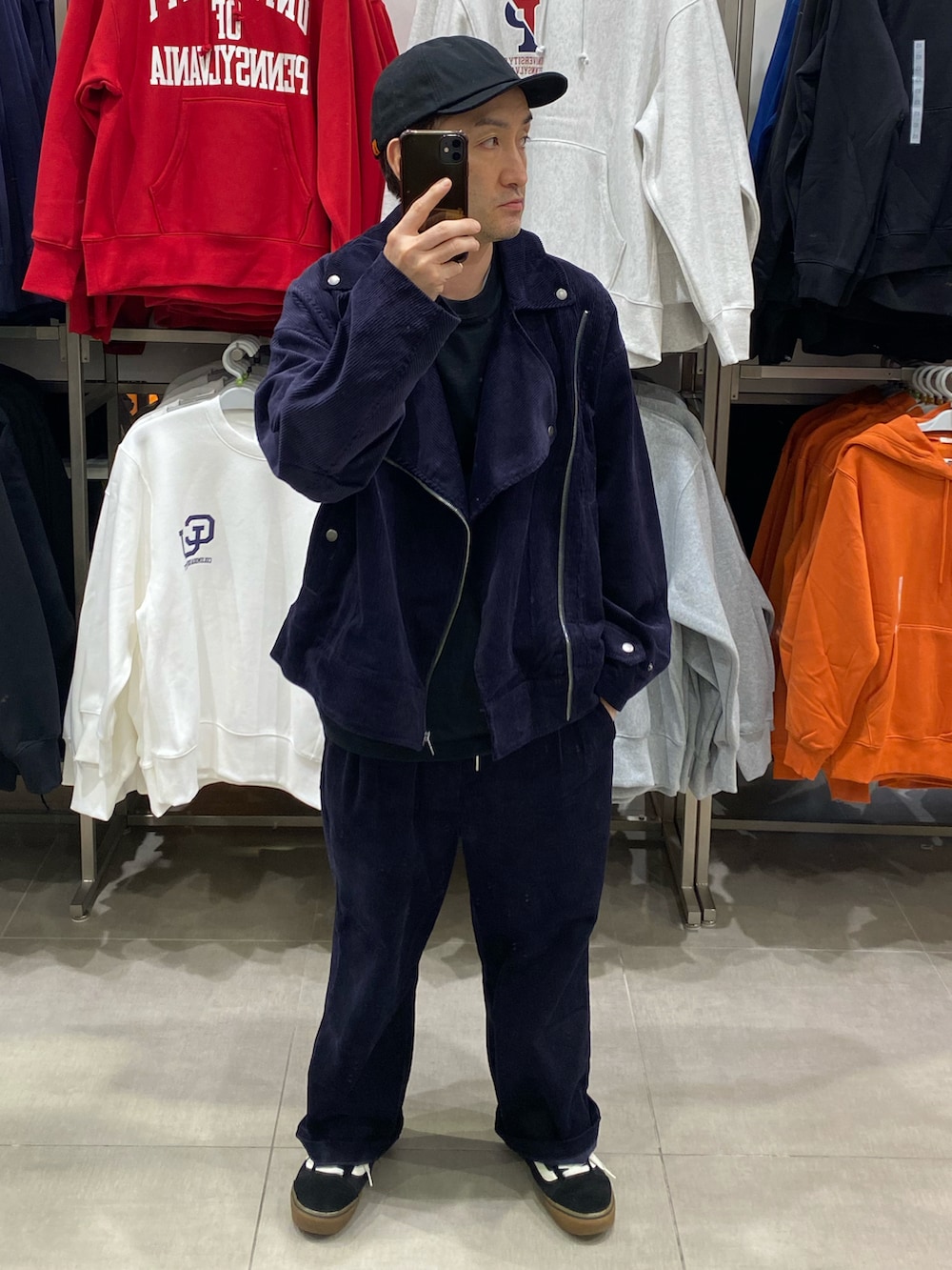 ブルー系のライダースジャケット、ブラック系のショルダーバッグ、ブラック系のスニーカーを着用したメンズの秋コーディネートの3枚目の写真