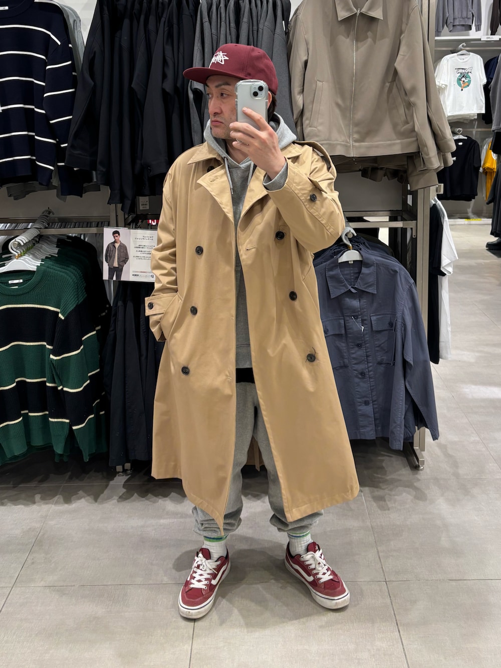 ベージュ系のトレンチコート、グレー系のパーカー、グレー系のスウェットパンツを着用したメンズの春コーディネートの2枚目の写真