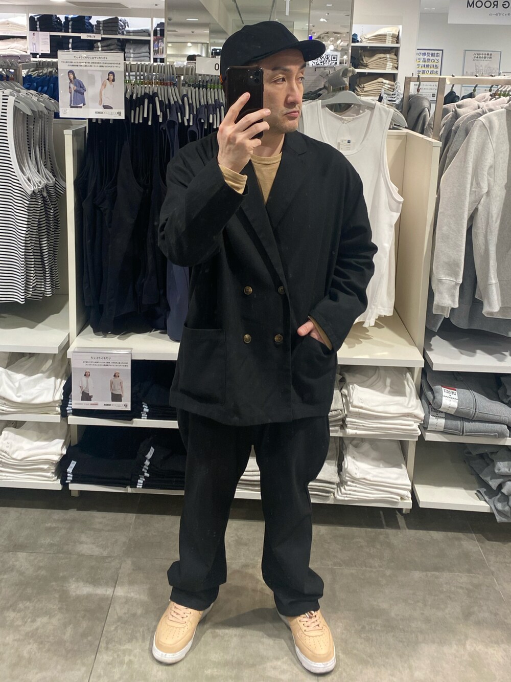 ブラック系のテーラードジャケット、ブラック系のその他パンツ、ベージュ系のスニーカーを着用したメンズの春コーディネートの4枚目の写真