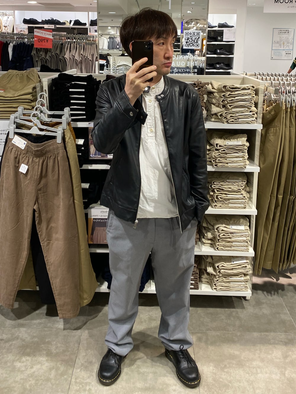 ブラック系のライダースジャケット、ブラック系のショルダーバッグ、グレー系のスラックスを着用したメンズの秋コーディネートの5枚目の写真