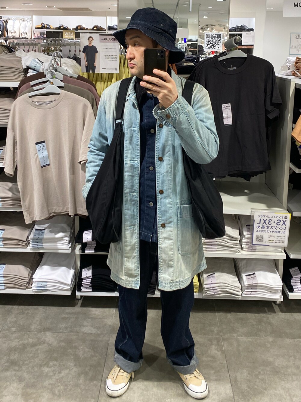 ブルー系のカバーオール、ブルー系のデニムパンツ、ベージュ系のスニーカーを着用したメンズの春コーディネートの4枚目の写真