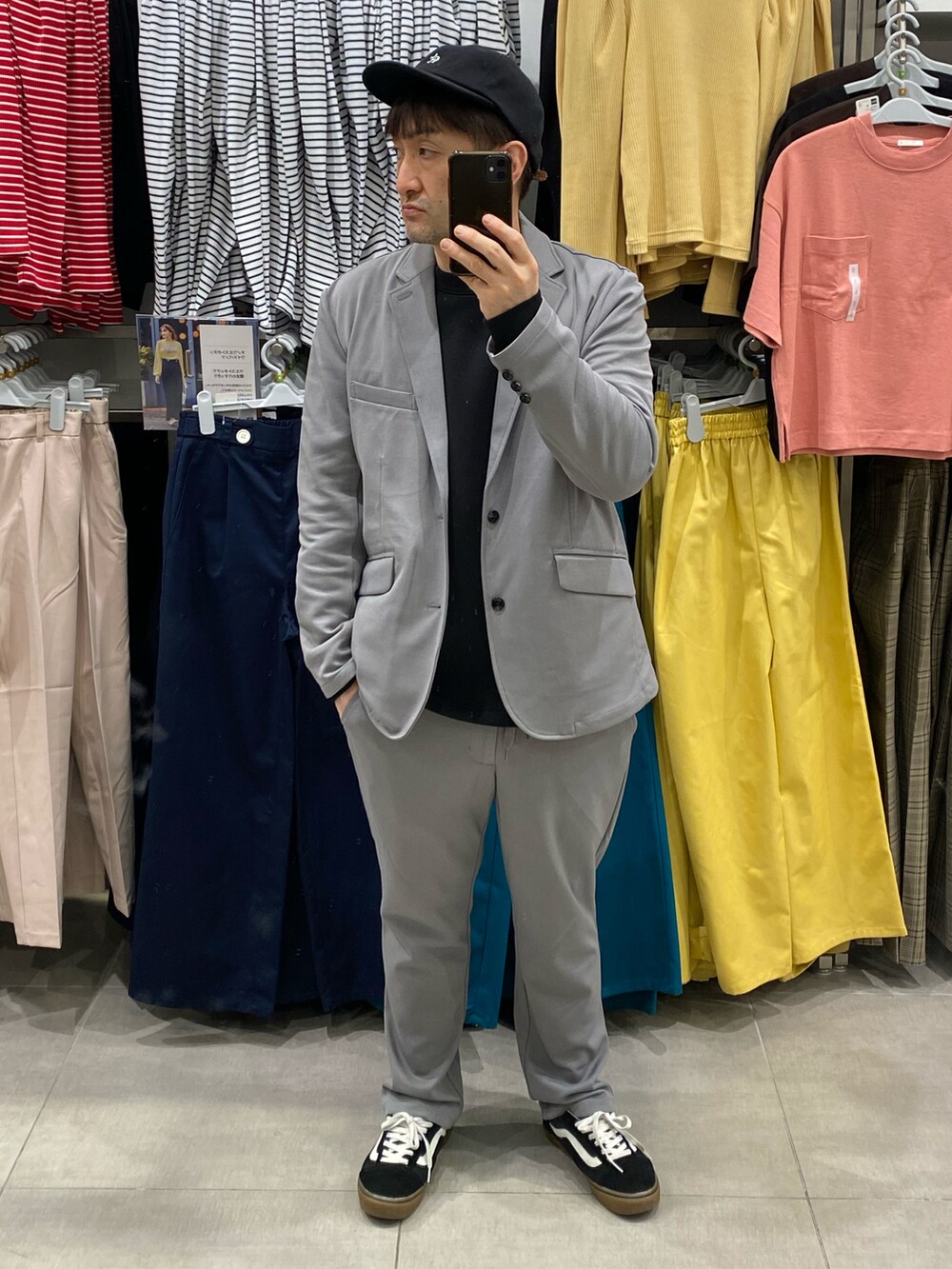 グレー系のセットアップ、ブラック系のスウェット、ブラック系のスニーカーを着用したメンズの春コーディネートの3枚目の写真