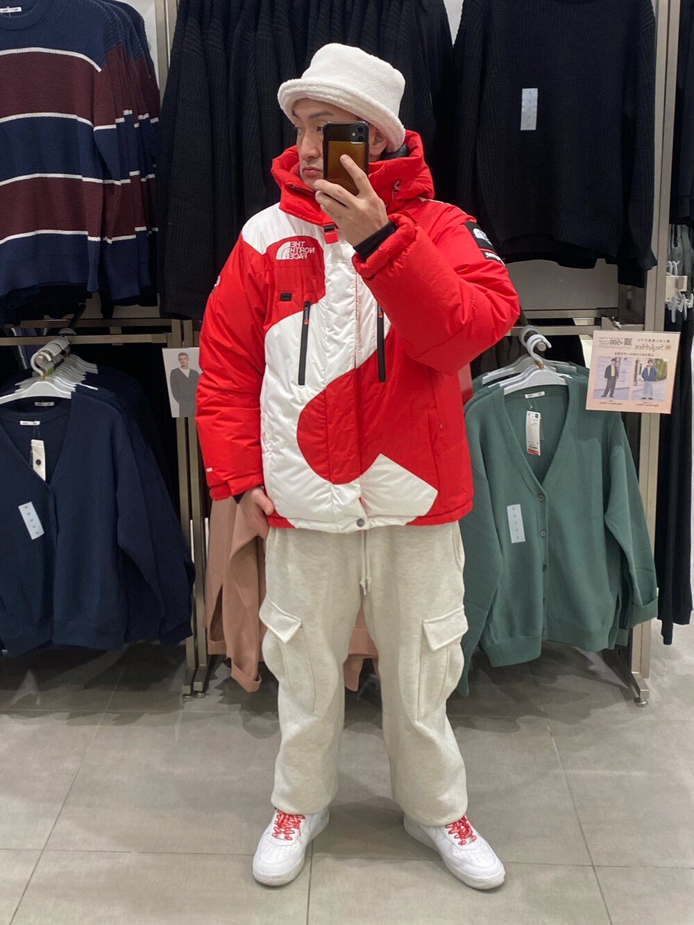 ホワイト系のスニーカー、グレー系のカーゴパンツ、レッド系のダウンジャケット/コートを着用したメンズの冬コーディネートの2枚目の写真