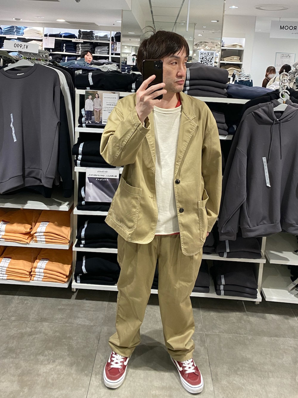 ベージュ系のテーラードジャケット、ベージュ系のパンツ、レッド系のスニーカーを着用したメンズの春コーディネートの3枚目の写真