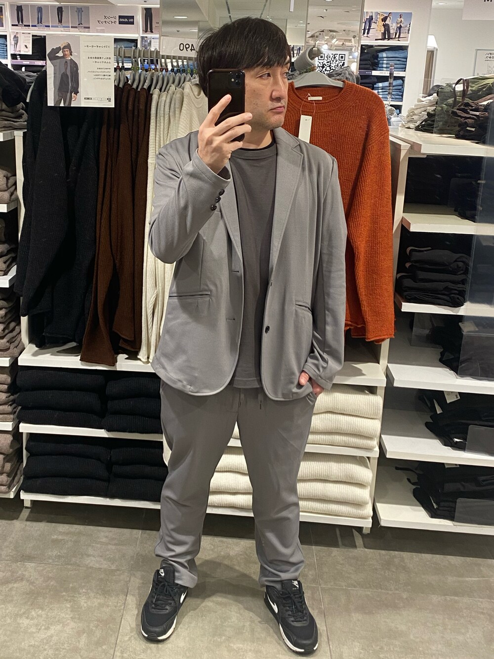 グレー系のテーラードジャケット、ブラック系のスニーカー、グレー系のTシャツ/カットソーを着用したメンズの秋コーディネートの4枚目の写真