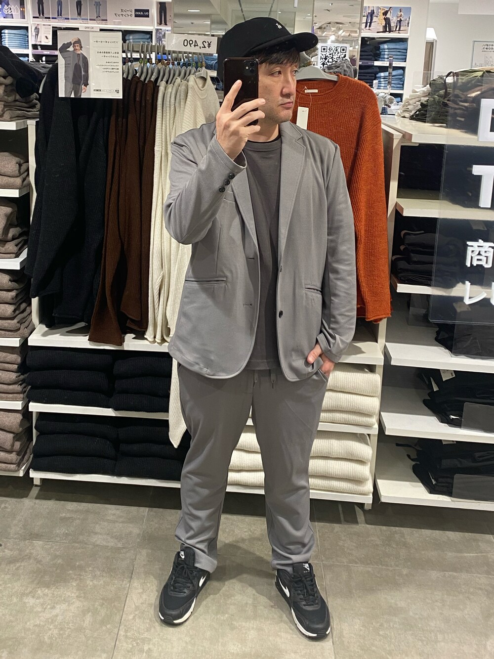 グレー系のテーラードジャケット、ブラック系のスニーカー、グレー系のTシャツ/カットソーを着用したメンズの秋コーディネートの3枚目の写真
