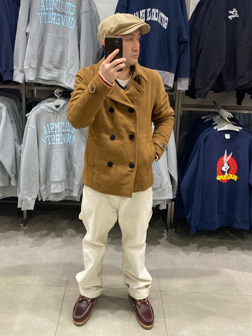ブラウン系のピーコート、ホワイト系のニット/セーター、ホワイト系のその他パンツを着用したメンズの冬コーディネートの4枚目の写真