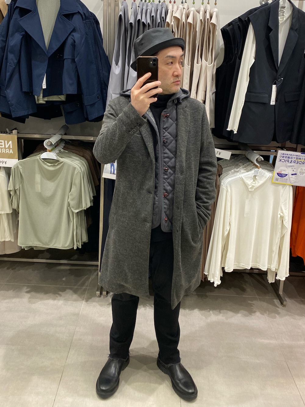 グレー系のチェスターコート、ブラック系のデニムパンツ、ブラック系のブーツを着用したメンズの春コーディネートの5枚目の写真