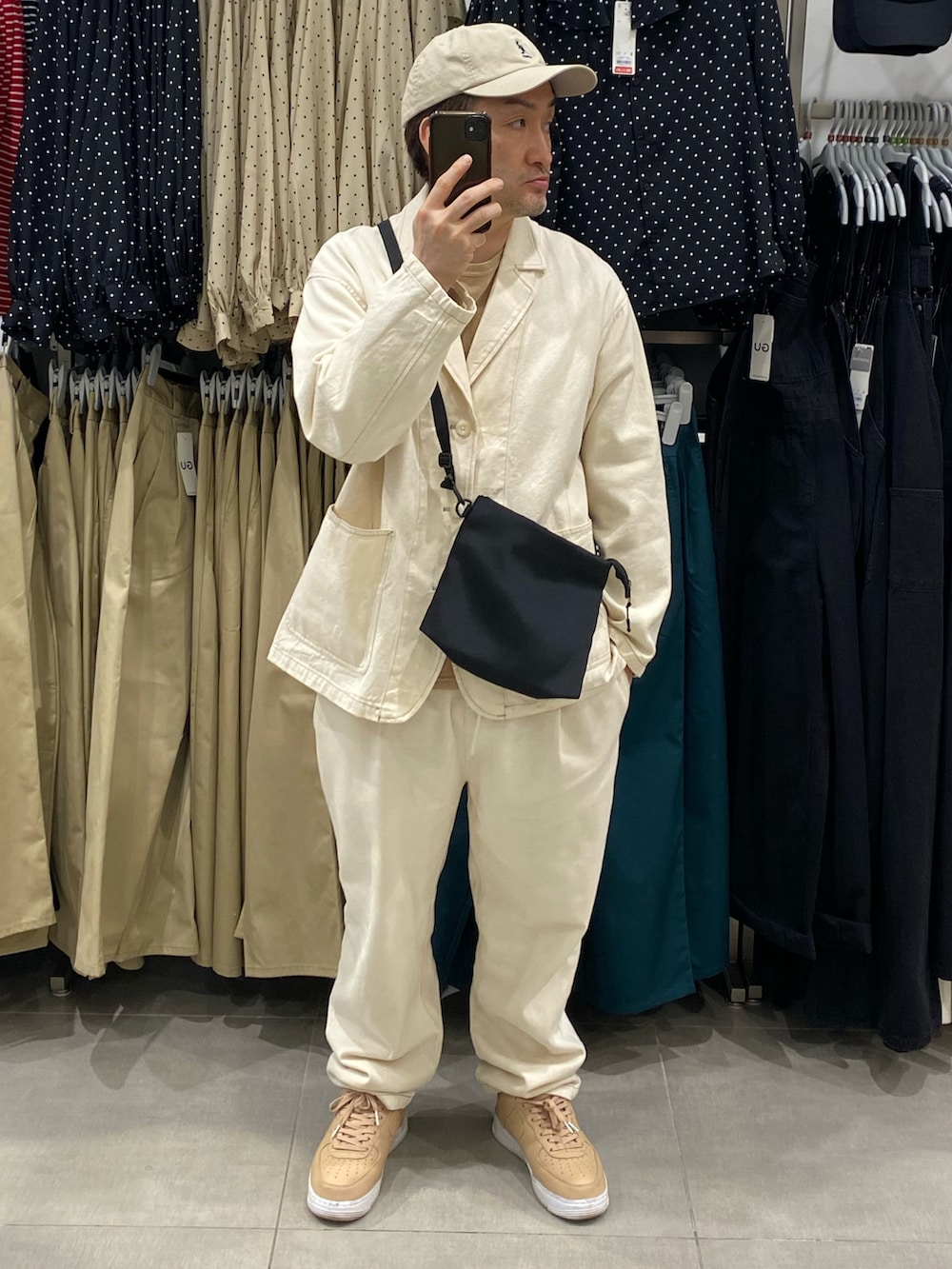 ベージュ系のその他トップス、ホワイト系のテーラードジャケット、ブラック系のショルダーバッグを着用したメンズの春コーディネートの3枚目の写真