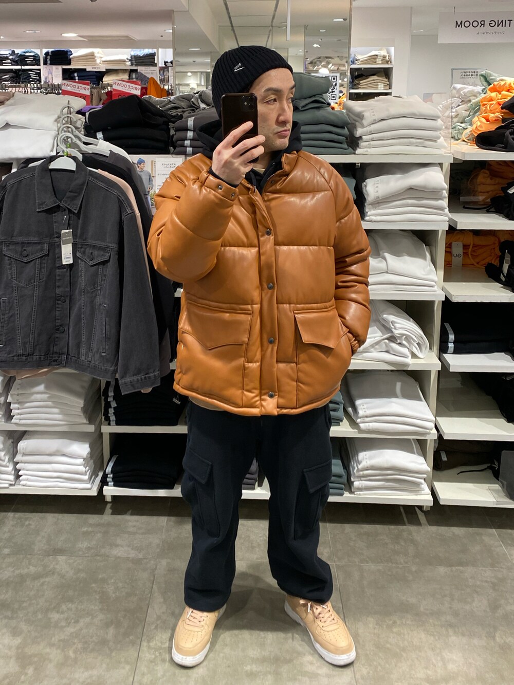 ブラウン系のダウンジャケット/コート、ブラック系のカーゴパンツ、ベージュ系のスニーカーを着用したメンズの冬コーディネートの4枚目の写真