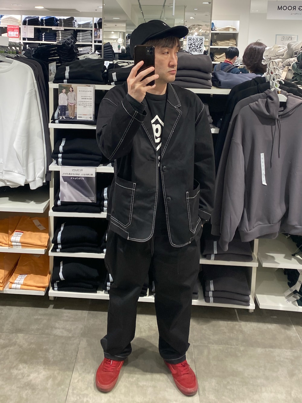 ブラック系のテーラードジャケット、ブラック系のその他パンツ、レッド系のスニーカーを着用したメンズの春コーディネートの2枚目の写真