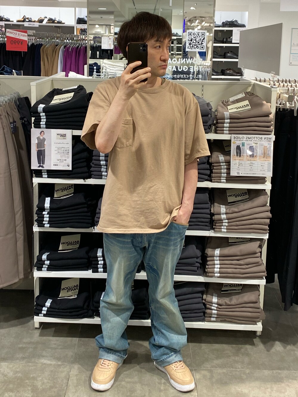ベージュ系のTシャツ/カットソー、ブルー系のデニムパンツ、ベージュ系のスニーカーを着用したメンズの秋コーディネートの3枚目の写真