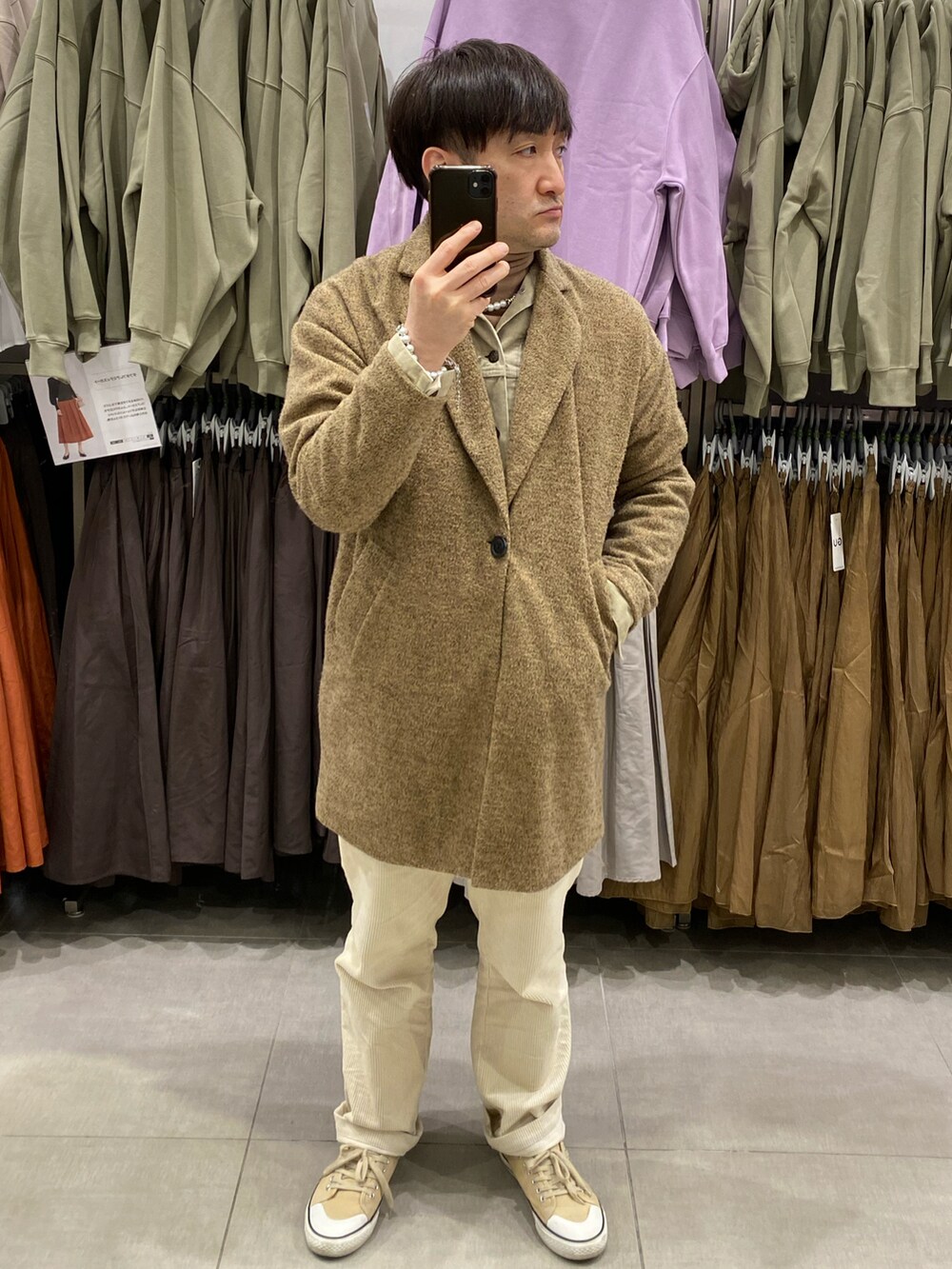 ベージュ系のチェスターコート、ホワイト系のその他パンツ、ベージュ系のスニーカーを着用したメンズの冬コーディネートの3枚目の写真