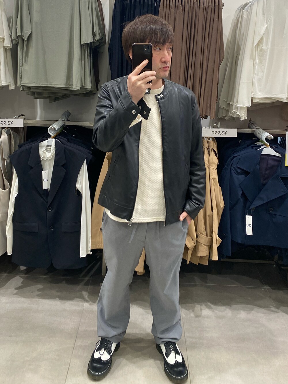 ホワイト系のニット/セーター、グレー系のスラックス、ブラック系のドレスシューズを着用したメンズの春コーディネートの3枚目の写真