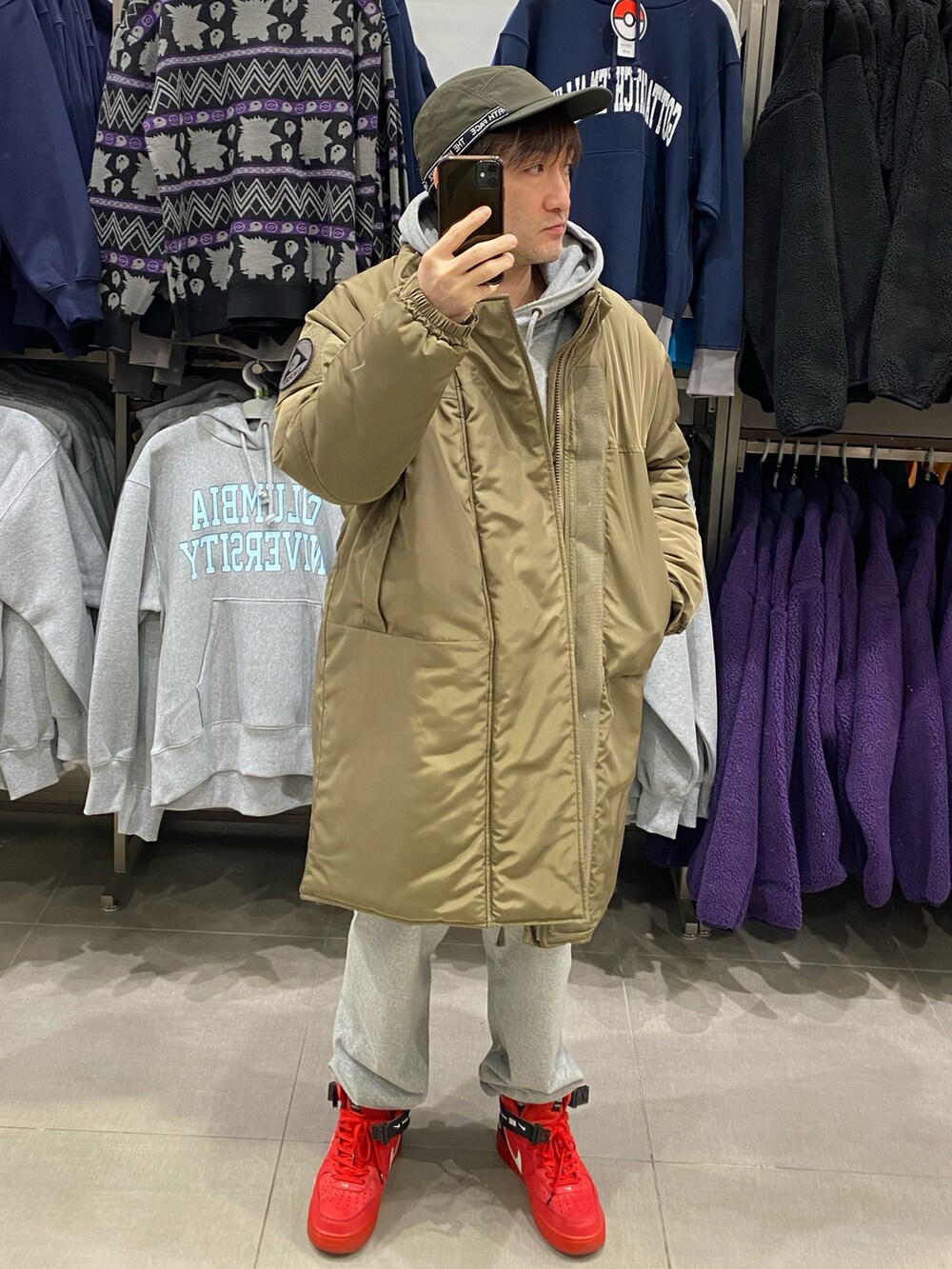 グリーン系のダウンジャケット/コート、グレー系のカーゴパンツ、レッド系のスニーカーを着用したメンズの冬コーディネートの2枚目の写真