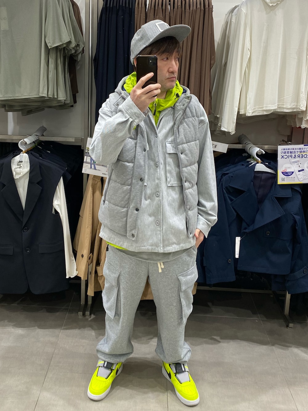 グレー系のダウンベスト、グレー系のカバーオール、グレー系のスウェットパンツを着用したメンズの春コーディネートの2枚目の写真