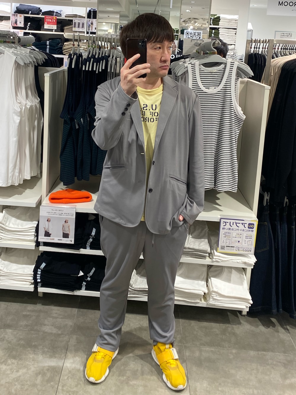 グレー系のセットアップ、イエロー系のTシャツ/カットソー、イエロー系のスニーカーを着用したメンズの夏コーディネートの3枚目の写真