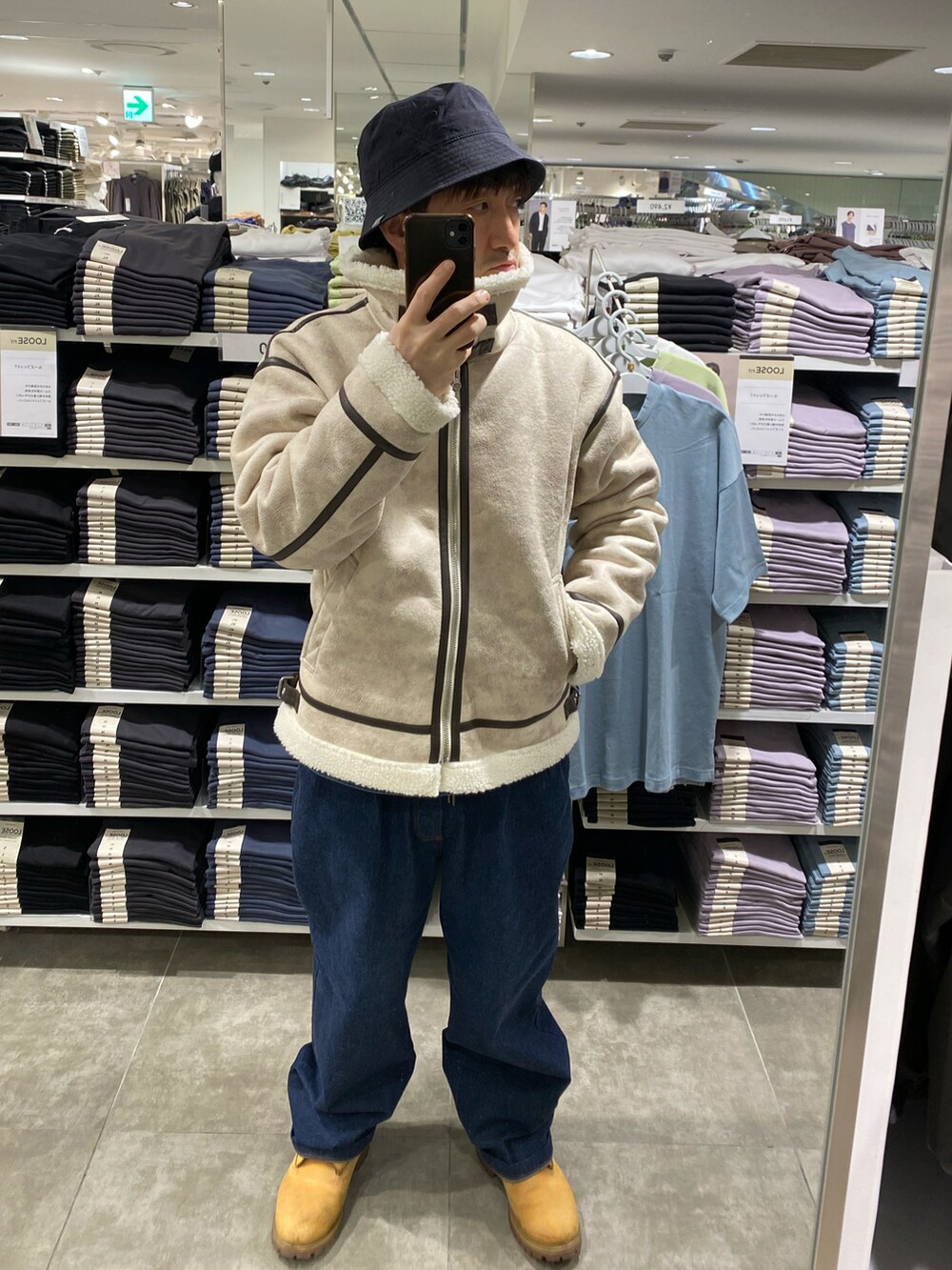 ホワイト系のブルゾン、ブルー系のデニムパンツ、ベージュ系のブーツを着用したメンズの冬コーディネートの2枚目の写真