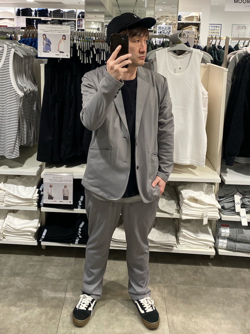 グレー系のセットアップ、ブラック系のTシャツ/カットソー、ブラック系のスニーカーを着用したメンズの春コーディネートの2枚目の写真