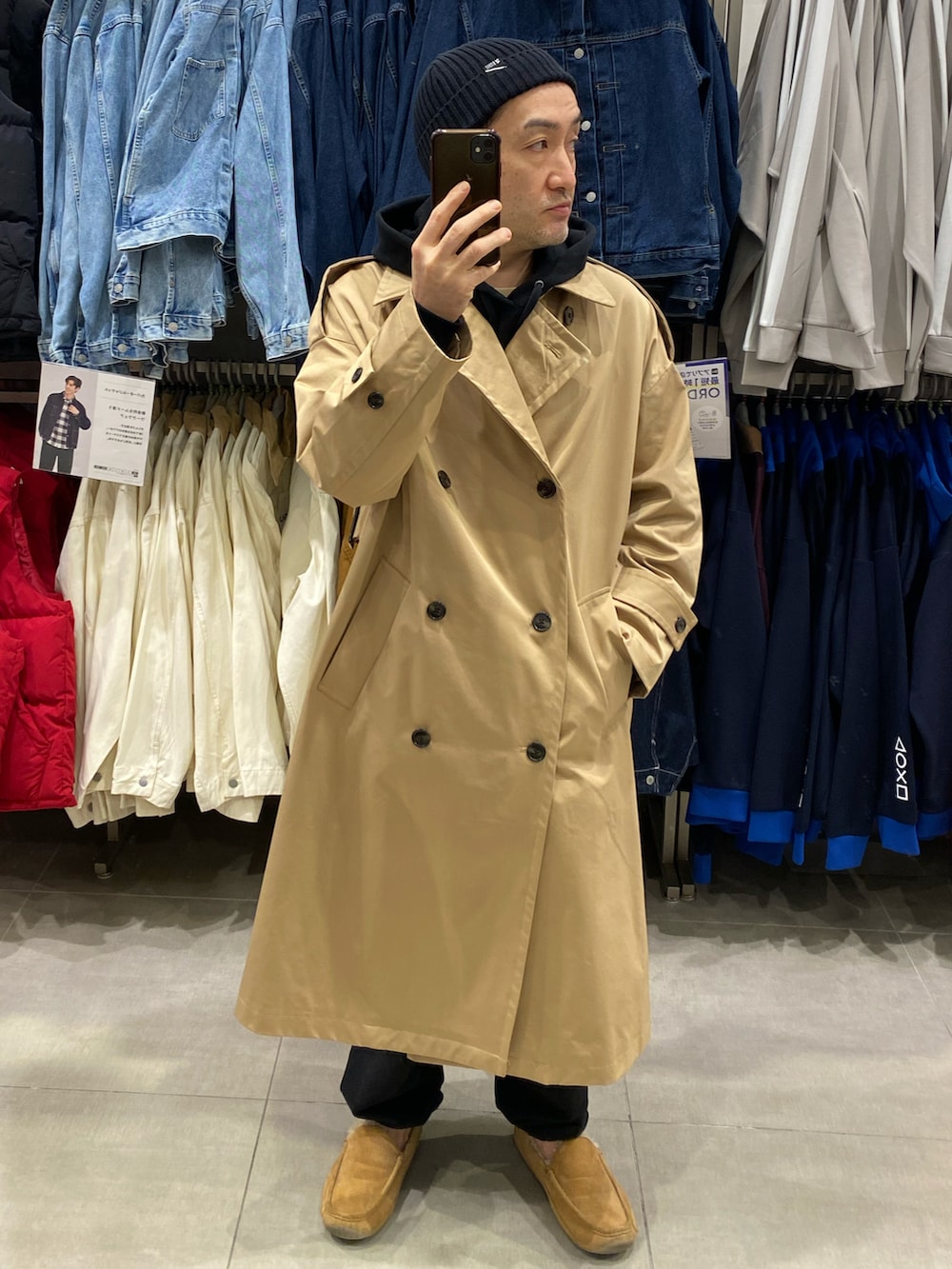 ブラック系のパーカー、ベージュ系のトレンチコート、ベージュ系のモカシン/デッキシューズを着用したメンズの秋コーディネートの4枚目の写真