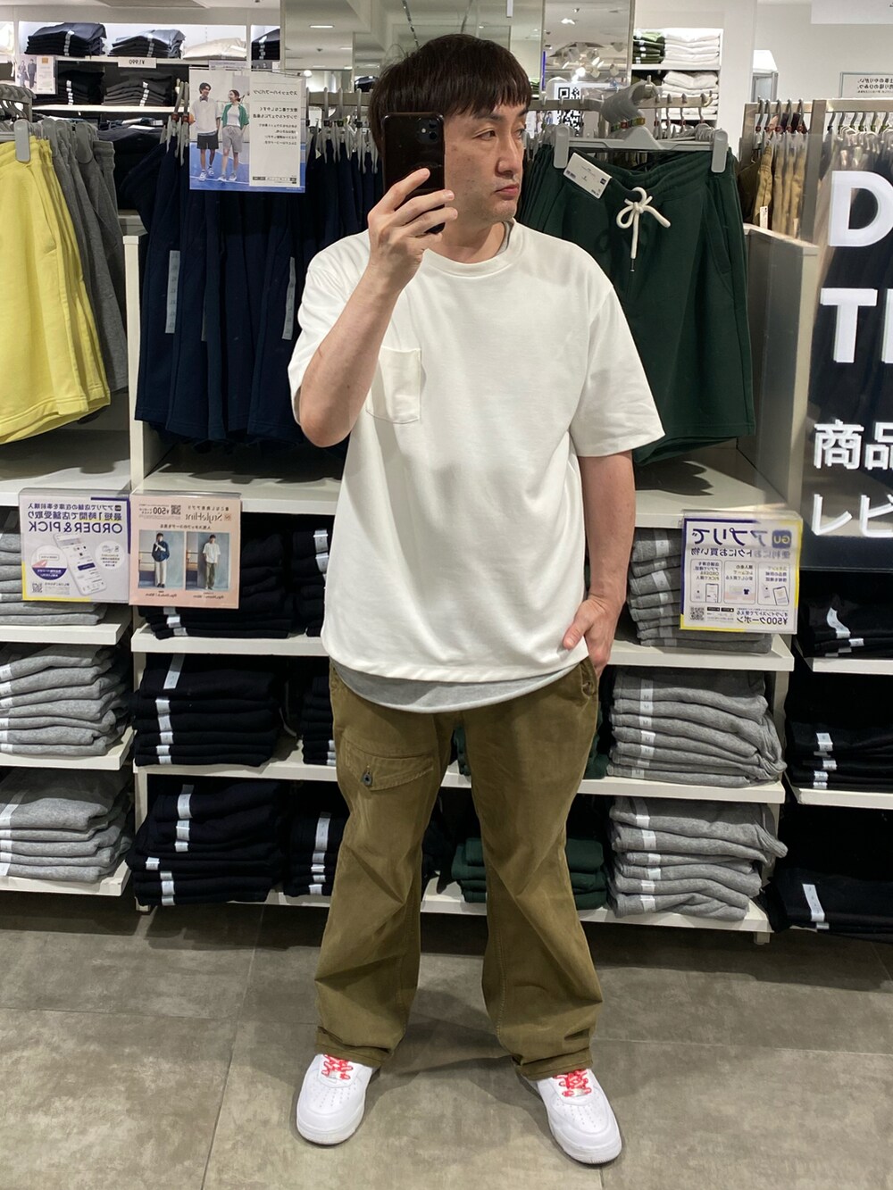 ホワイト系のTシャツ/カットソー、グリーン系のカーゴパンツ、ホワイト系のスニーカーを着用したメンズの夏コーディネートの3枚目の写真