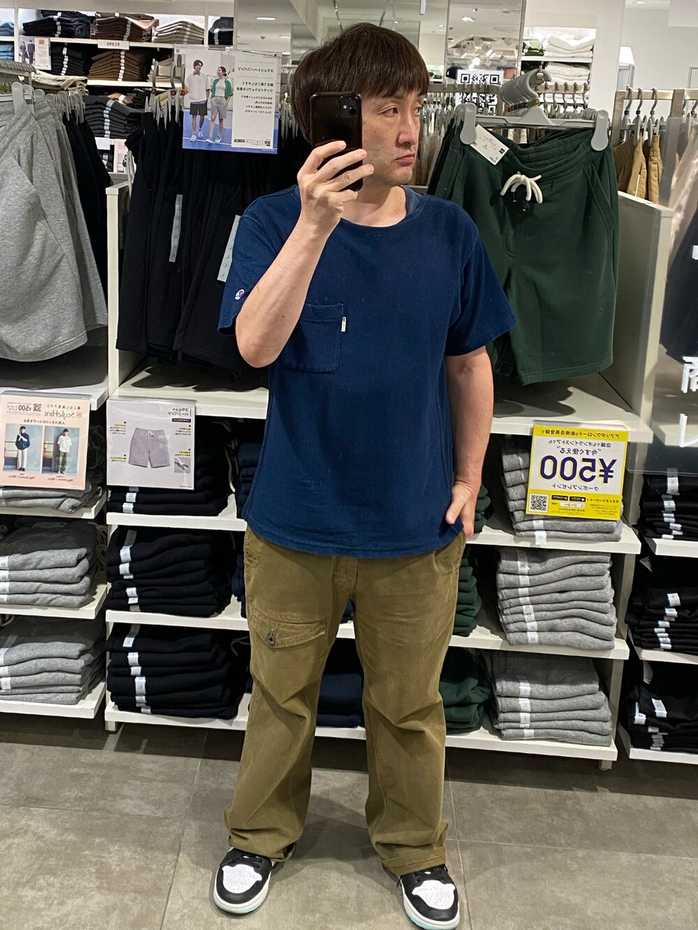 ブルー系のTシャツ/カットソー、グリーン系のカーゴパンツ、ホワイト系のスニーカーを着用したメンズの夏コーディネートの3枚目の写真