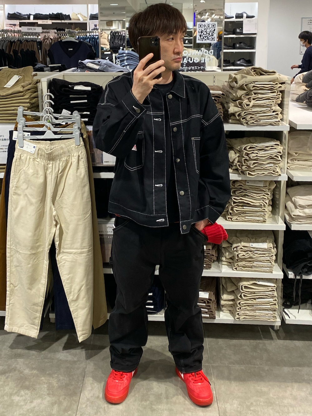 ブラック系のデニムジャケット、ブラック系のその他パンツ、レッド系のスニーカーを着用したメンズの秋コーディネートの4枚目の写真