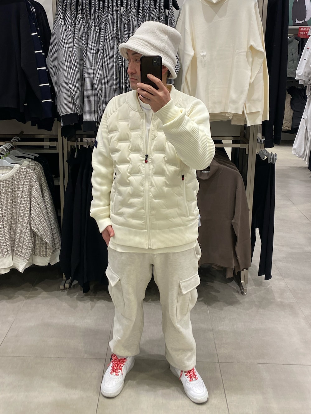 グレー系のカーゴパンツ、ホワイト系のスニーカー、ホワイト系のブルゾンを着用したメンズの冬コーディネートの2枚目の写真