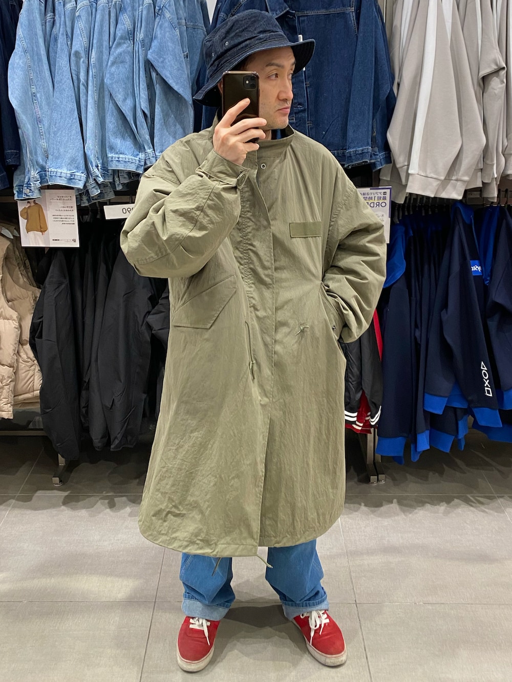 グリーン系のモッズコート、ブルー系のデニムジャケット、ブルー系のデニムパンツを着用したメンズの秋コーディネートの4枚目の写真