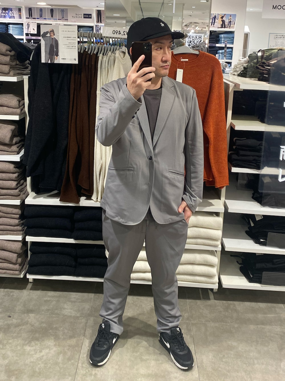 グレー系のテーラードジャケット、ブラック系のスニーカー、グレー系のTシャツ/カットソーを着用したメンズの秋コーディネートの2枚目の写真