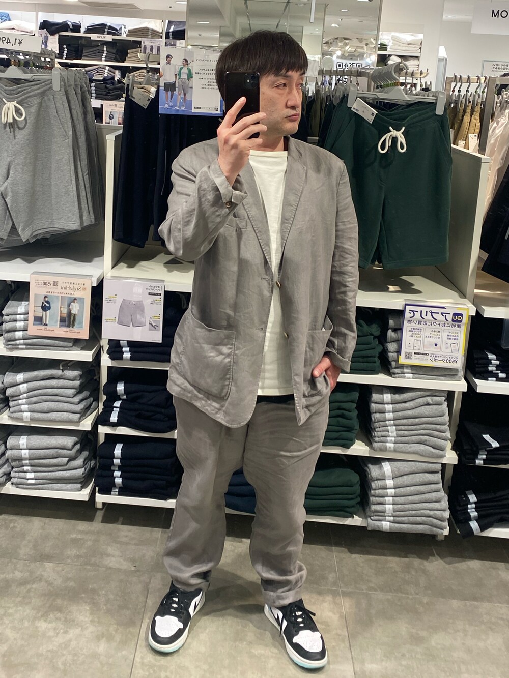 ホワイト系のスニーカー、グレー系のテーラードジャケット、グレー系のその他パンツを着用したメンズの夏コーディネートの3枚目の写真