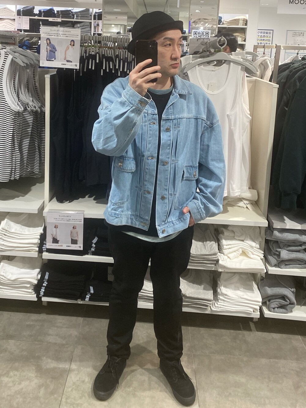 ブルー系のデニムジャケット、ブラック系のパンツ、ブラック系のスニーカーを着用したメンズの春コーディネートの2枚目の写真