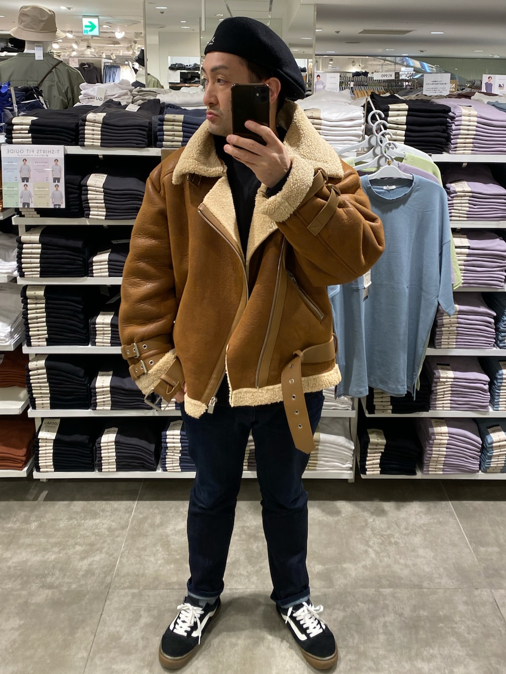 ブラウン系のムートンコート、ブルー系のデニムパンツ、ブラック系のスニーカーを着用したメンズの冬コーディネートの2枚目の写真