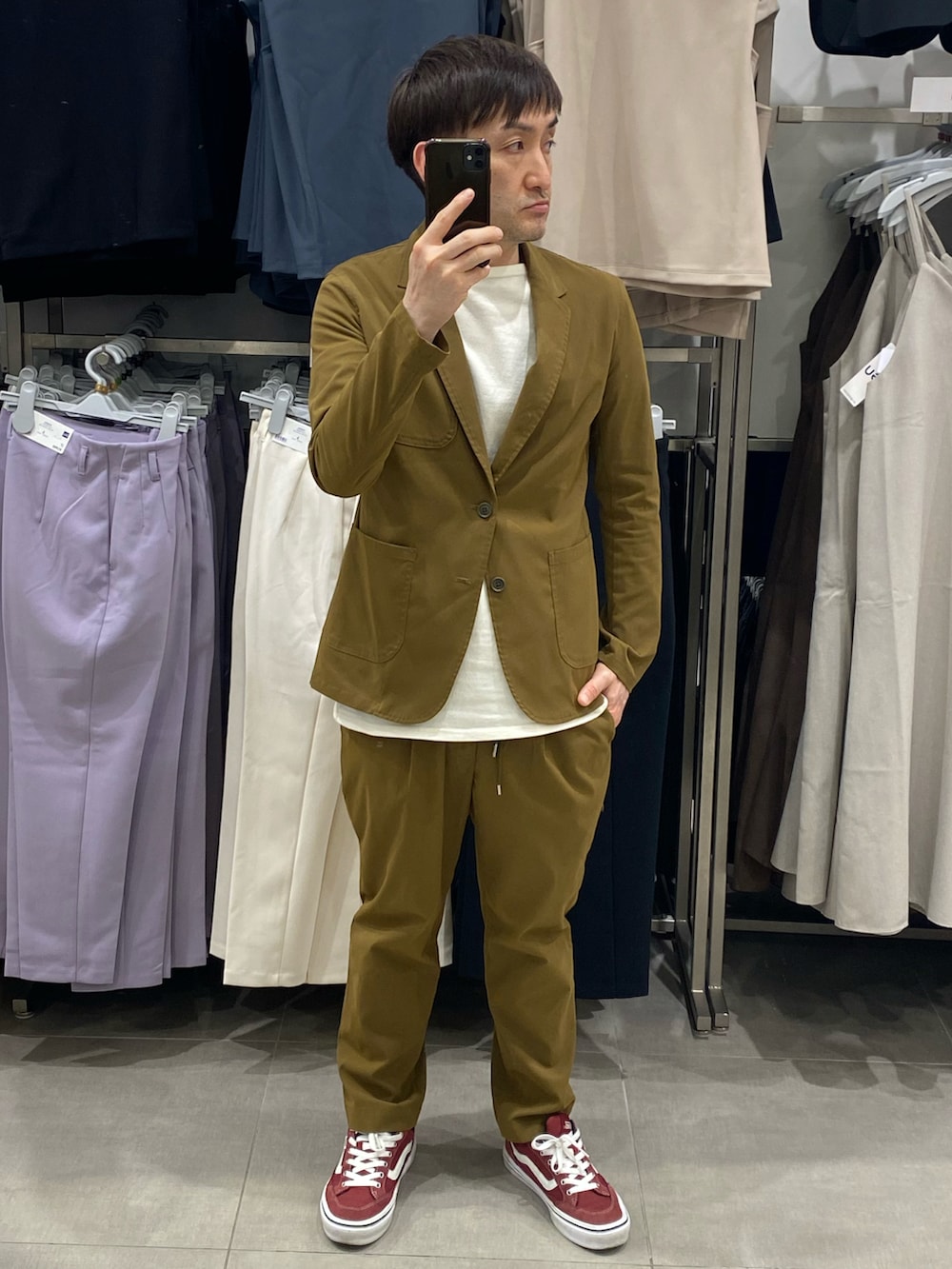 ブラウン系のテーラードジャケット、ブラウン系のスラックス、レッド系のスニーカーを着用したメンズの夏コーディネートの3枚目の写真