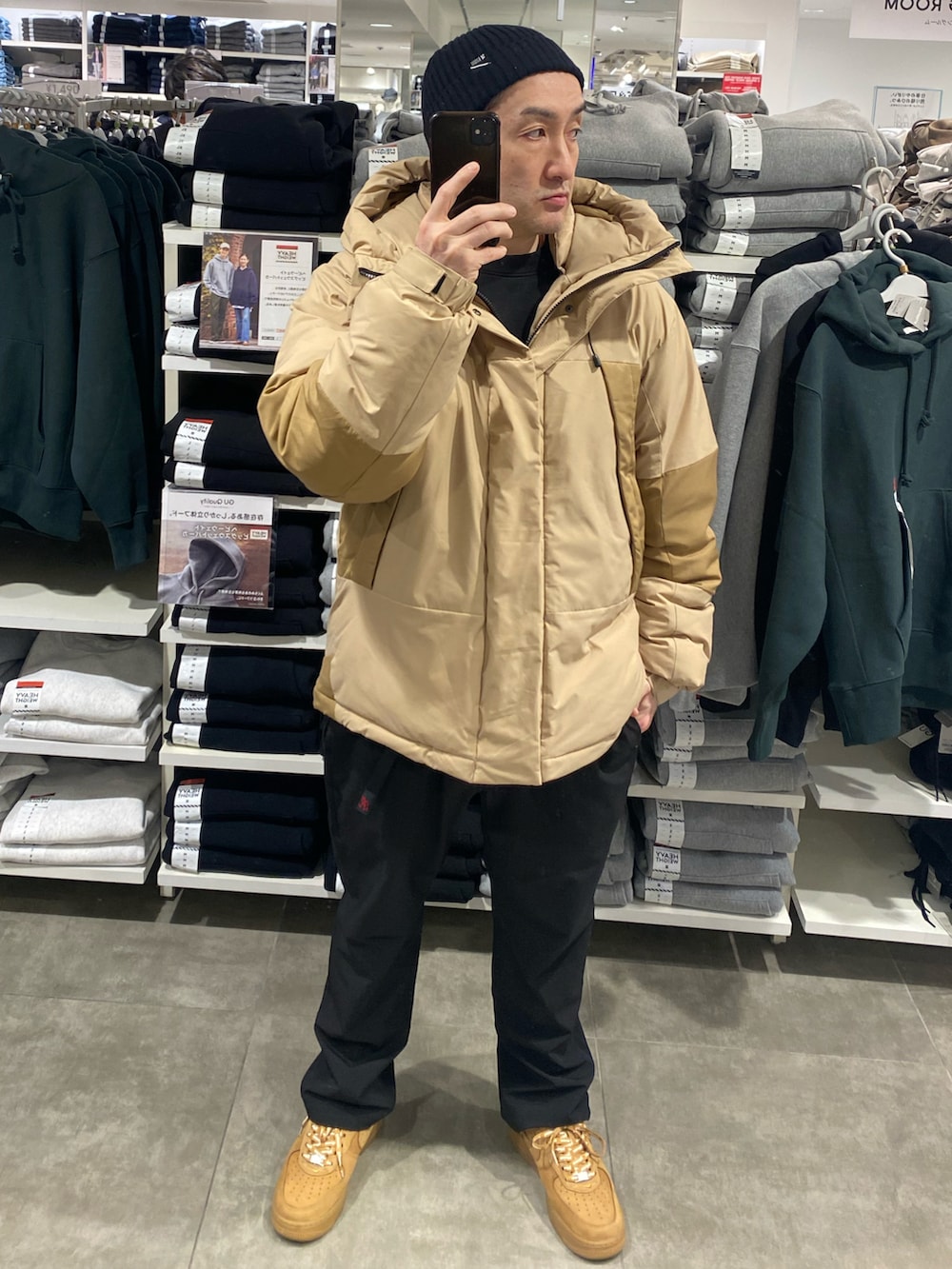 ベージュ系のダウンジャケット/コート、ブラック系のその他パンツ、ブラウン系のスニーカーを着用したメンズの冬コーディネートの2枚目の写真