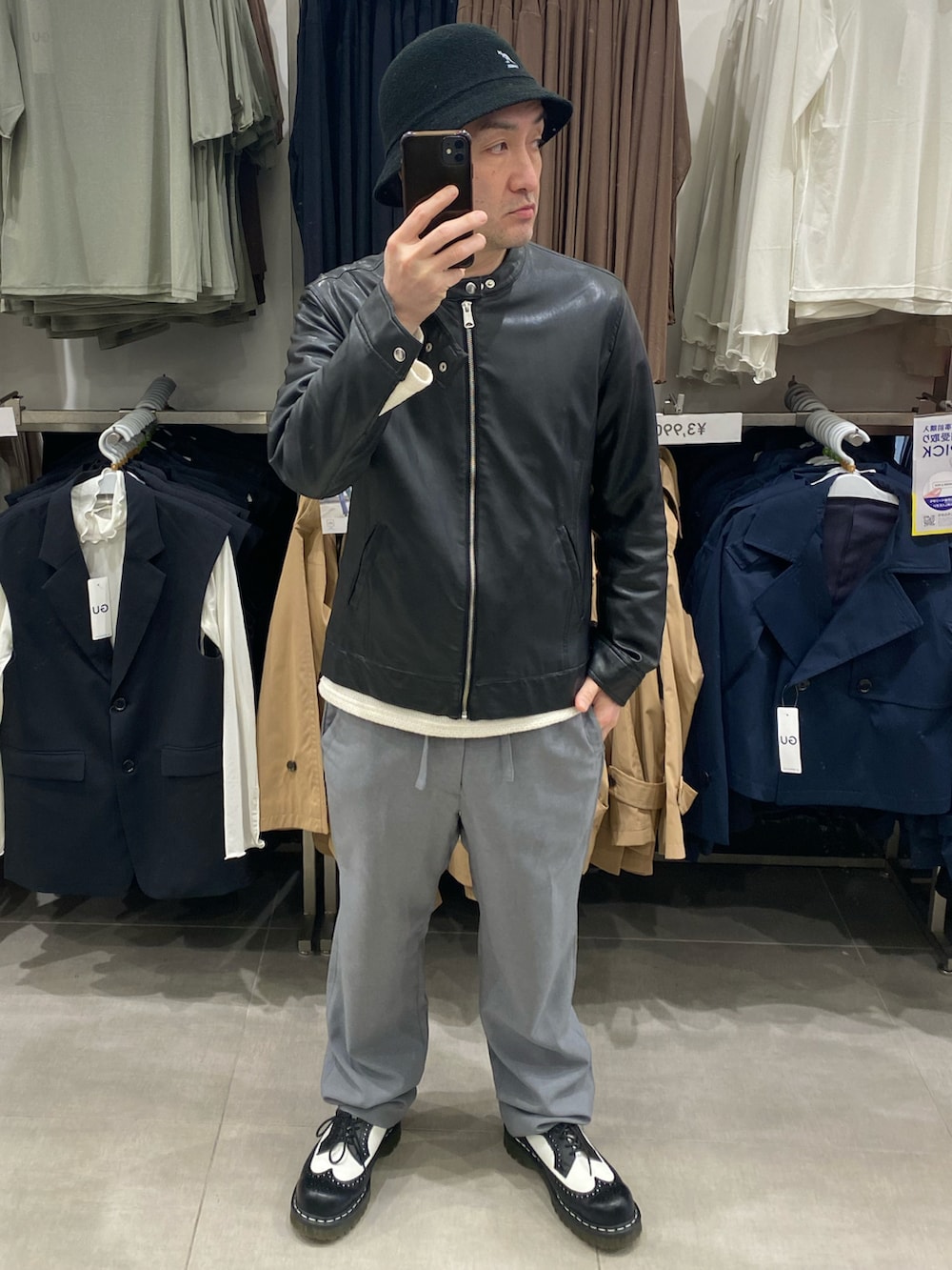 ホワイト系のニット/セーター、グレー系のスラックス、ブラック系のドレスシューズを着用したメンズの春コーディネートの4枚目の写真