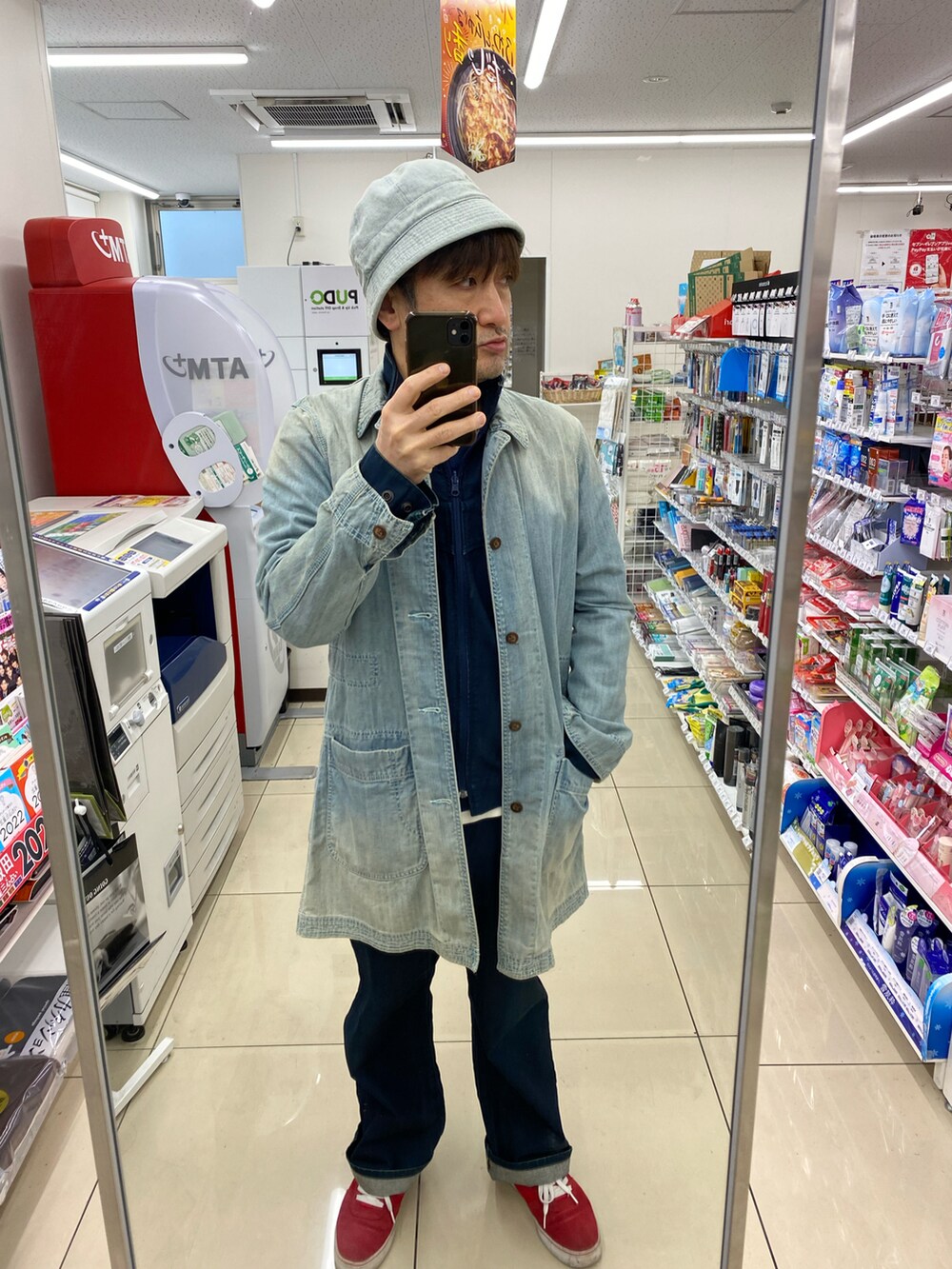 ブルー系のデニムジャケット、ブルー系のステンカラーコート、ブルー系のデニムパンツを着用したメンズの秋コーディネートの2枚目の写真