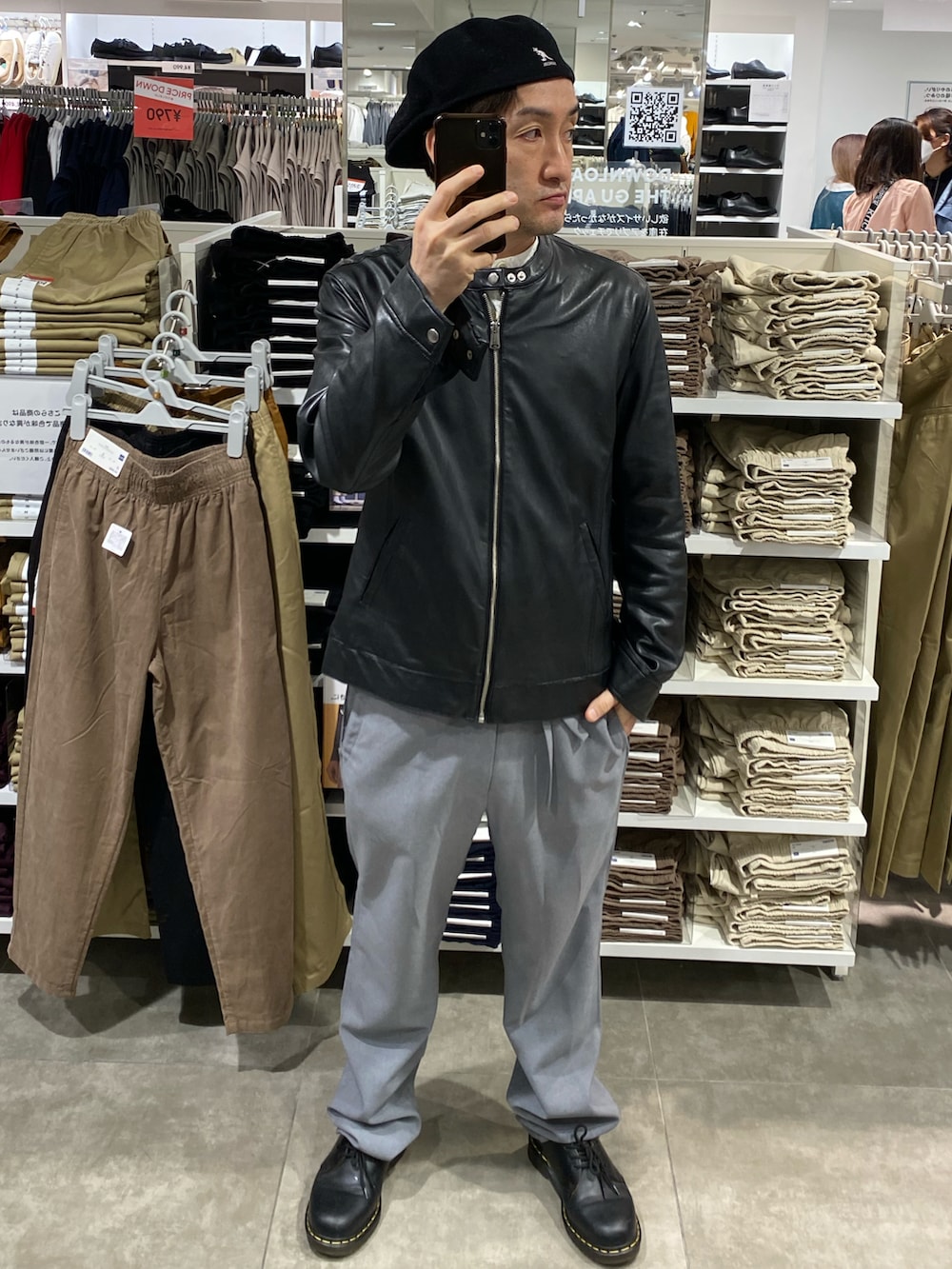 ブラック系のライダースジャケット、ブラック系のショルダーバッグ、グレー系のスラックスを着用したメンズの秋コーディネートの3枚目の写真
