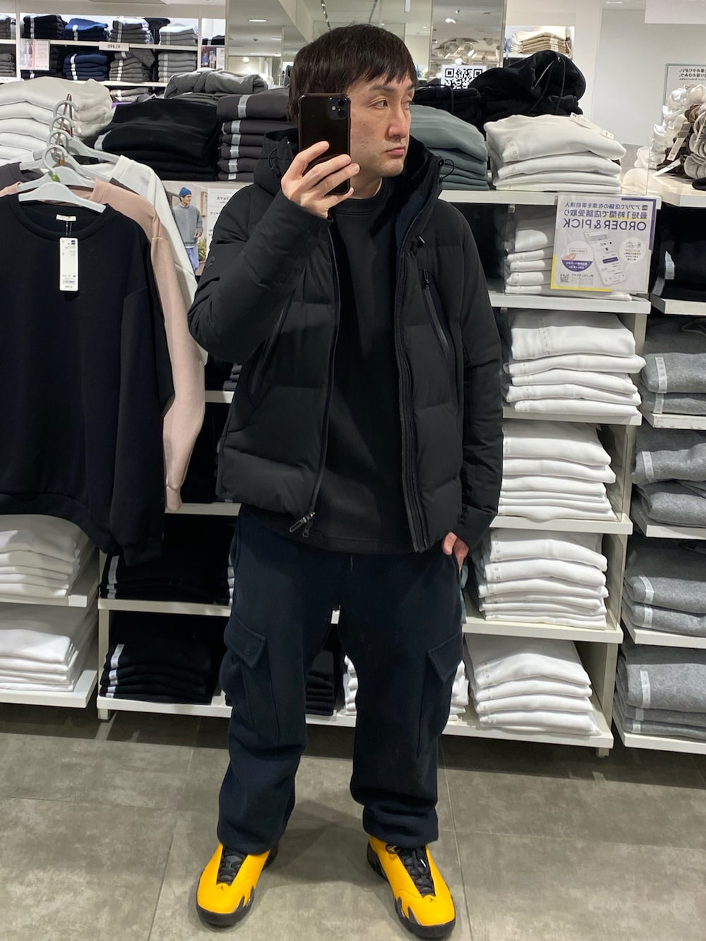 ブラック系のダウンジャケット/コート、ブラック系のスウェット、ブラック系のカーゴパンツを着用したメンズの冬コーディネートの3枚目の写真